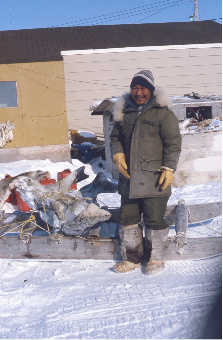 Photo of artist Judas Ullulaq outside with a piece of whale bone, may 1987