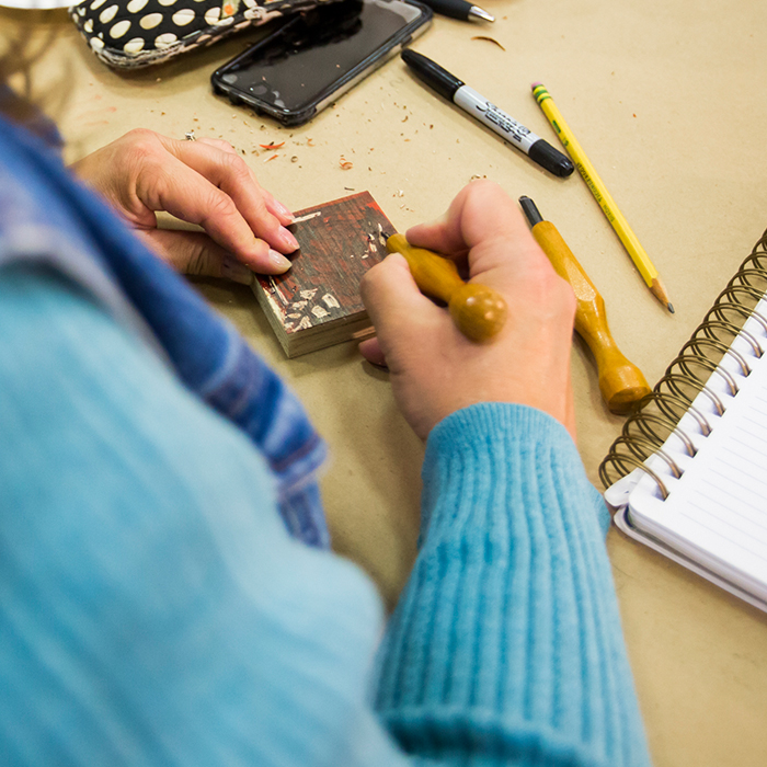 Teacher carves a wood block
