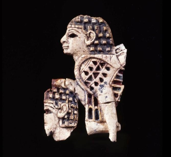Image of an ivory Furniture Fitting with a Sphinx Trampling a Nubian on a black background