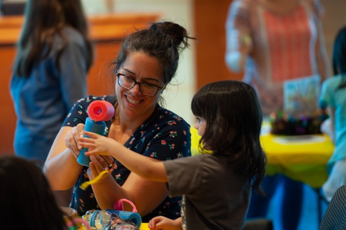 Adult and child sitting at table making art in Ackerman Hall