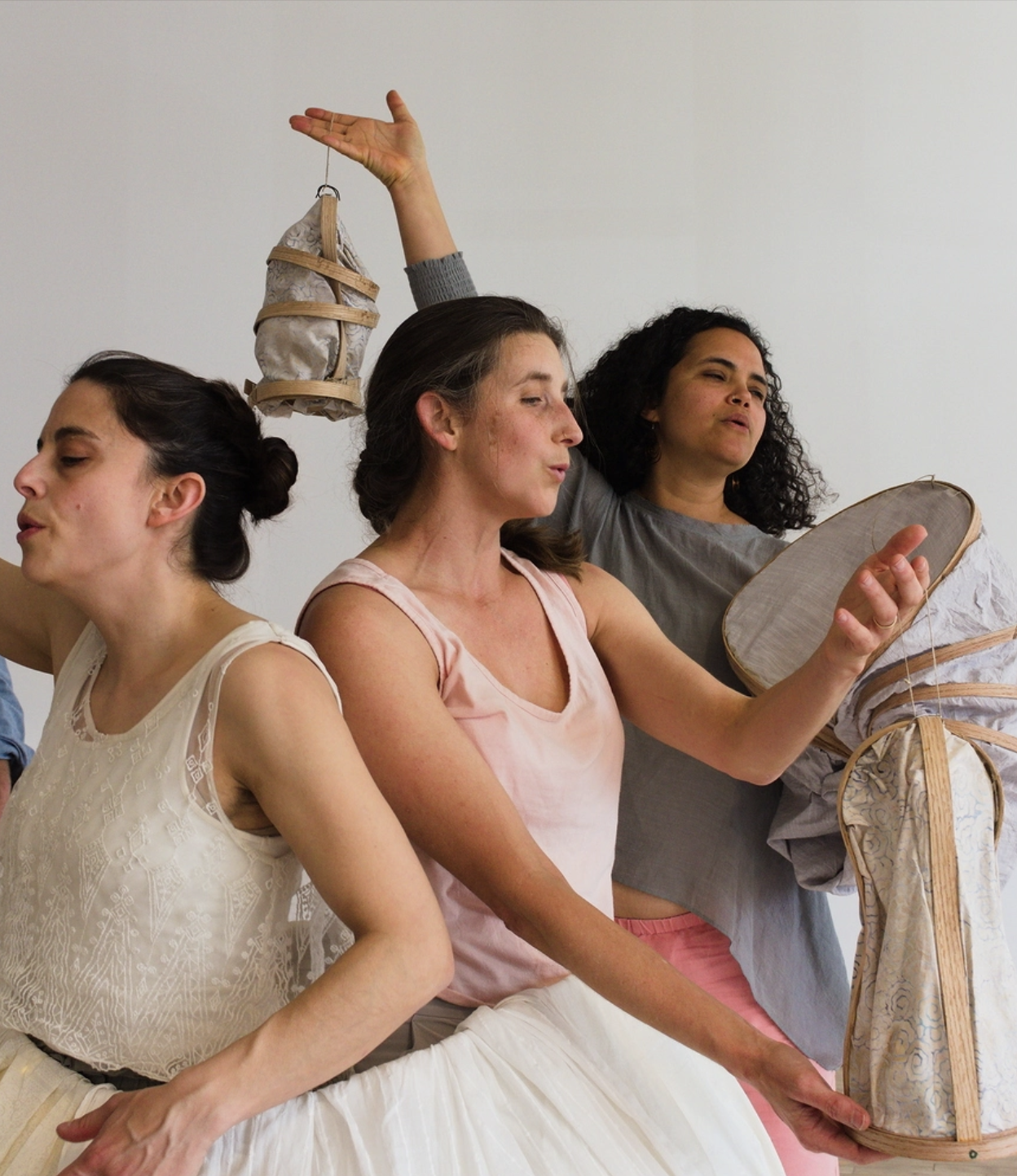 Image of three people holding objects in dynamic dance poses from Vulture Sister Song