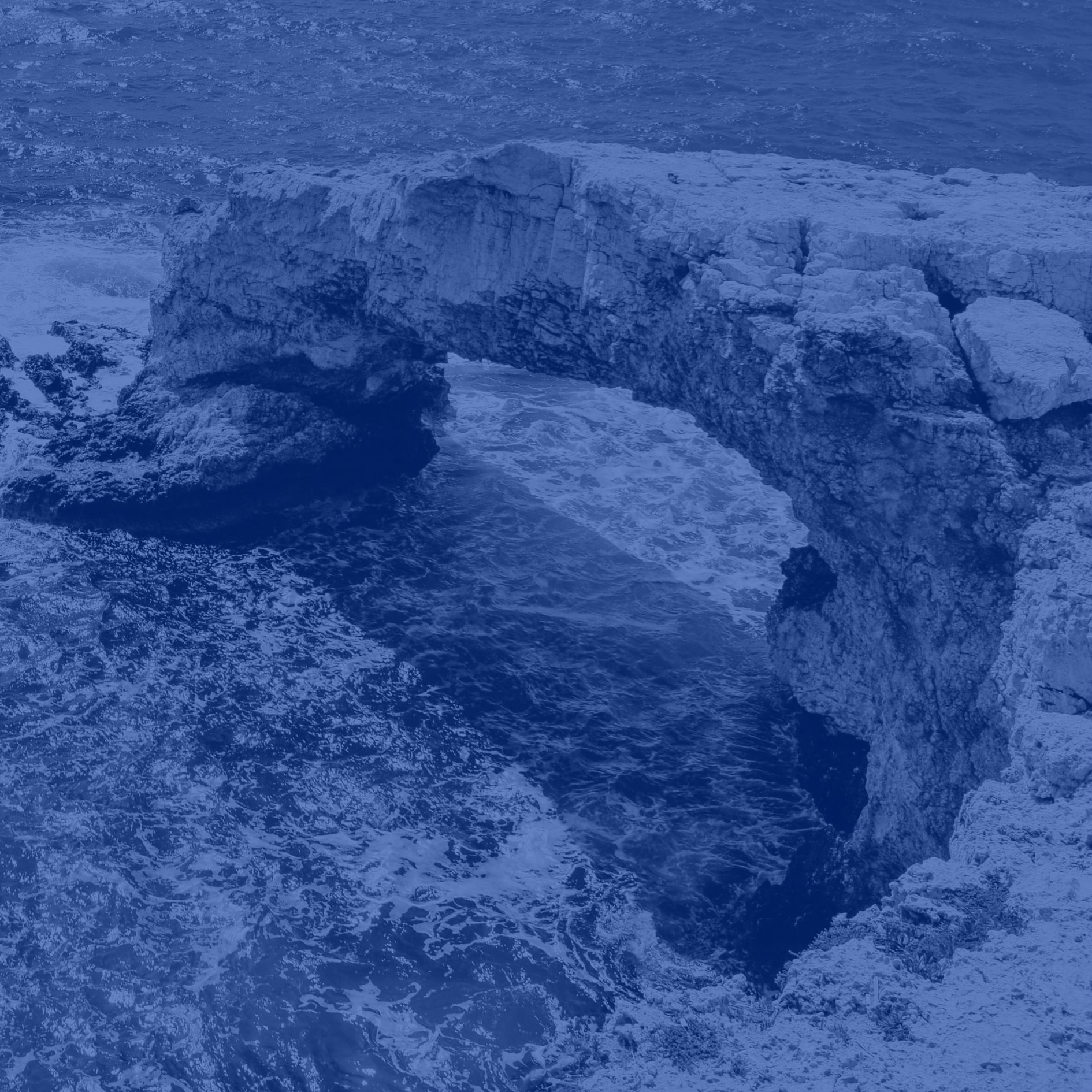 Image of ocean and cliff of Cyprus with a blue filter over it