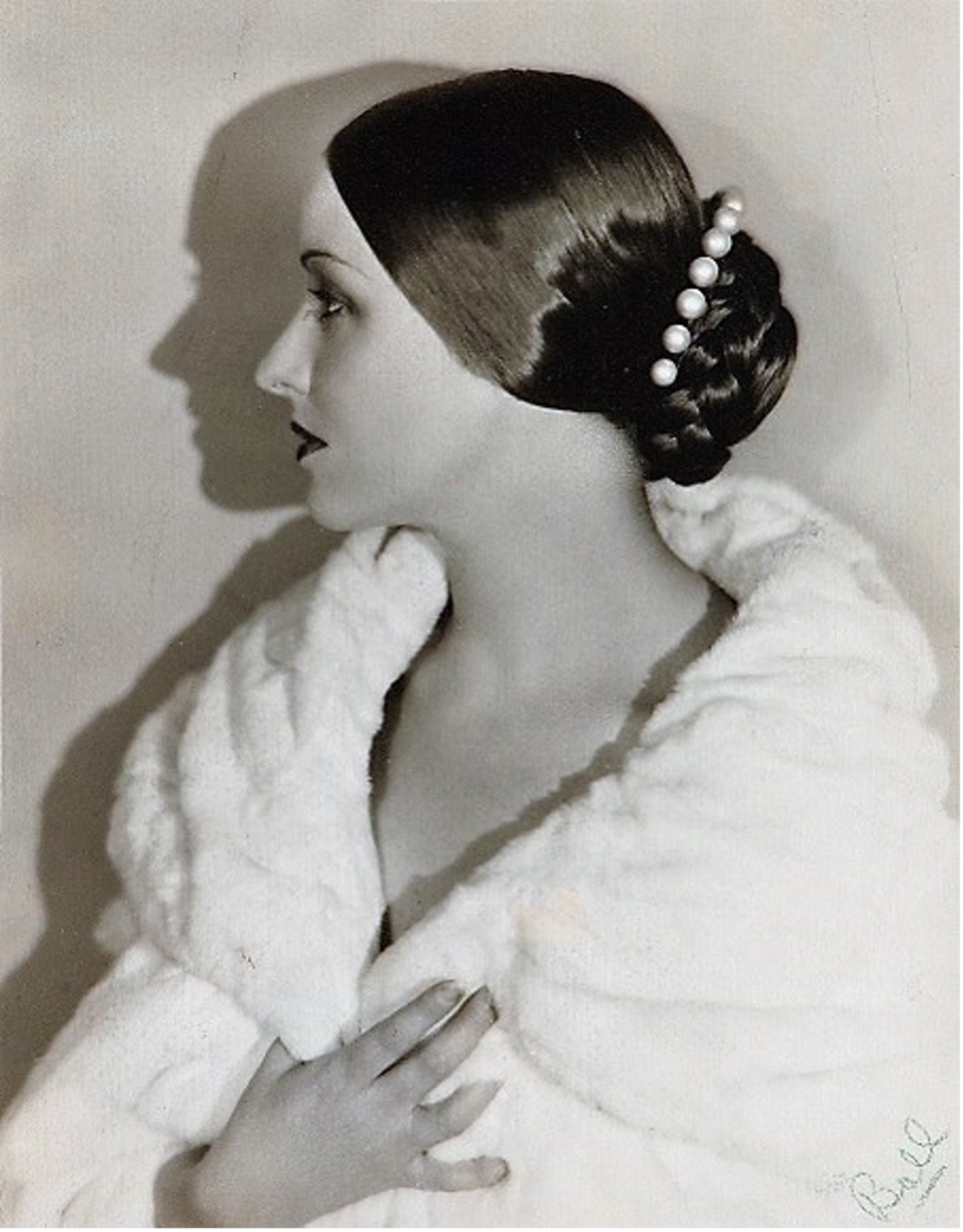 Black and white photograph of Natacha Rambova in profile wearing white fur coat