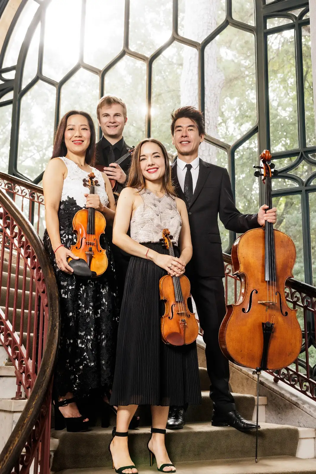 Vega String Quartet standing on stairs with their instruments