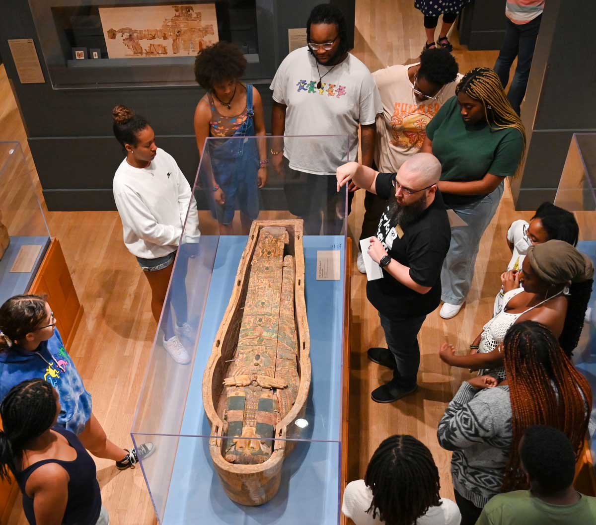 Group of people standing around Egyptian sarcophagus lid
