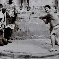 Children play baseball in the street