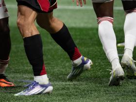 cropped photography by Sheila Pree Bright showing soccer players' legs and feet moving on the field during a soccer game 